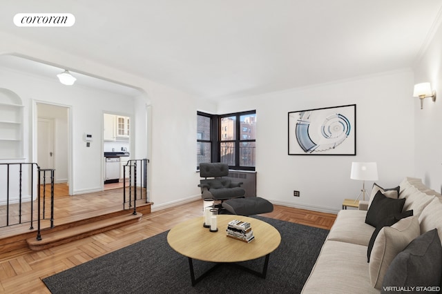 living room featuring visible vents, baseboards, built in features, ornamental molding, and arched walkways