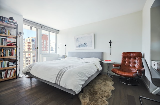 bedroom with baseboards and dark wood-type flooring