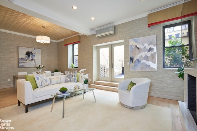 living area featuring ornamental molding, a wall mounted AC, wood finished floors, and baseboards