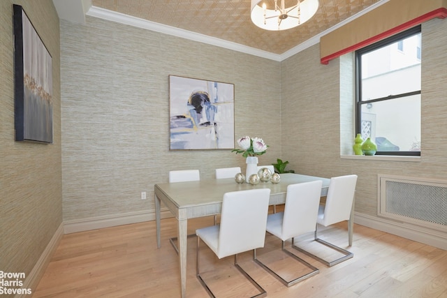 dining room with baseboards, wood finished floors, a chandelier, and crown molding