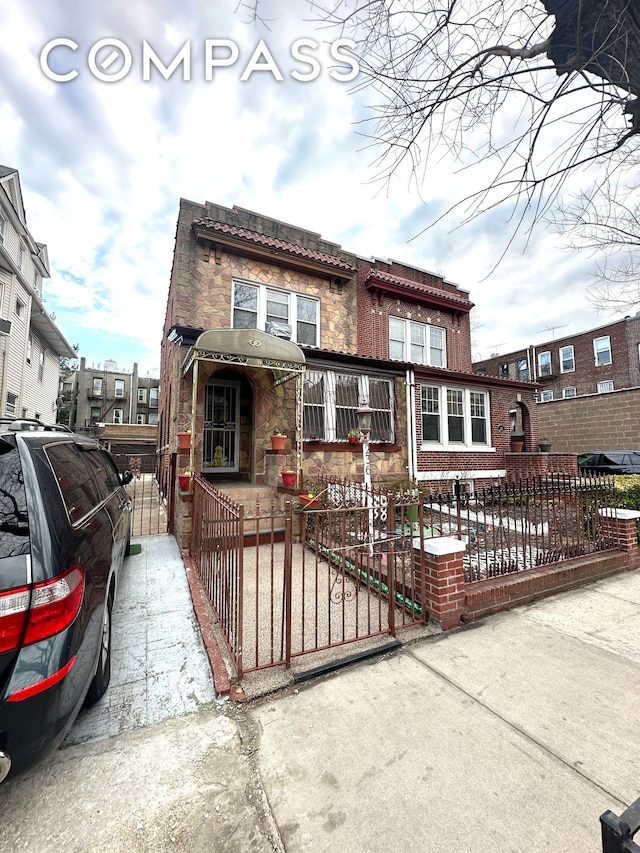 view of front of property with a fenced front yard and a gate