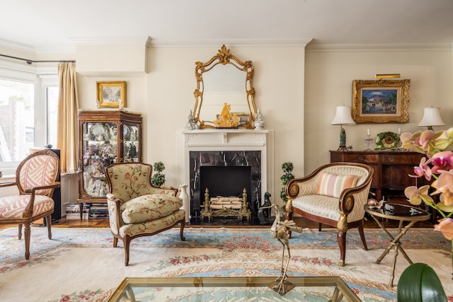 living area with a premium fireplace, wood finished floors, and ornamental molding