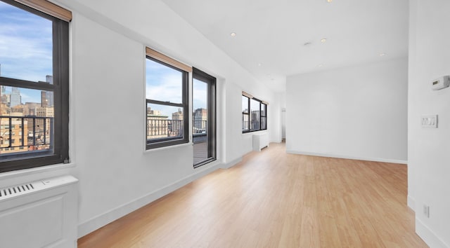 empty room featuring light wood-style floors, recessed lighting, and baseboards