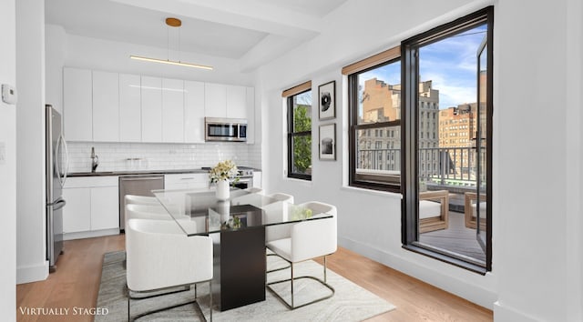 kitchen featuring modern cabinets, light wood-type flooring, and appliances with stainless steel finishes