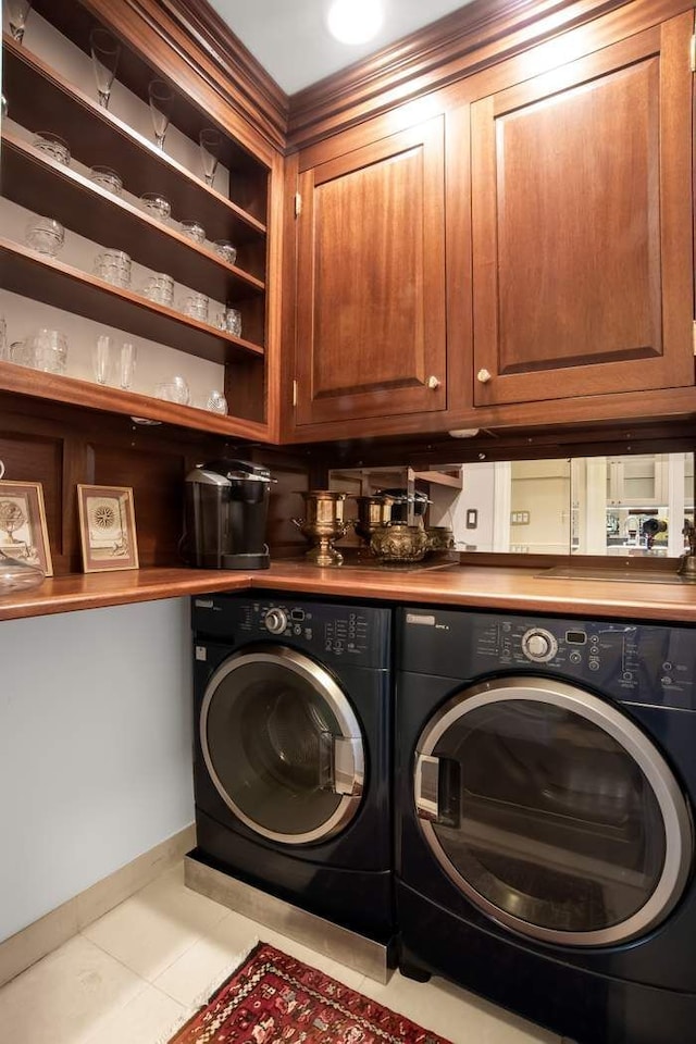 laundry area with cabinet space, independent washer and dryer, baseboards, and tile patterned floors