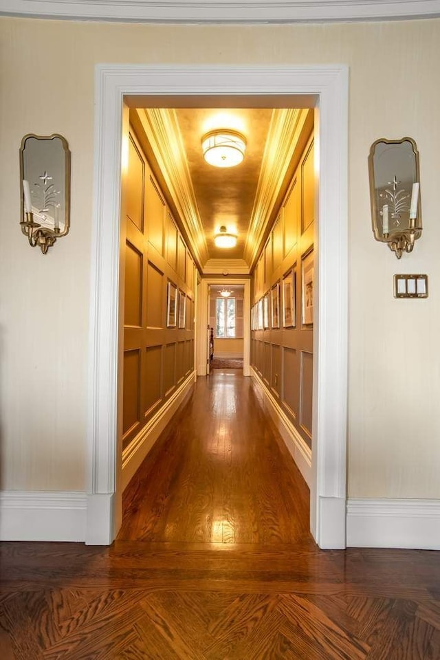 hallway with dark wood-style floors and ornamental molding