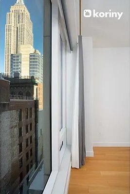 interior space with a city view, light wood-type flooring, and baseboards