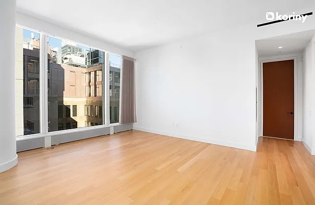 spare room with baseboards and wood finished floors