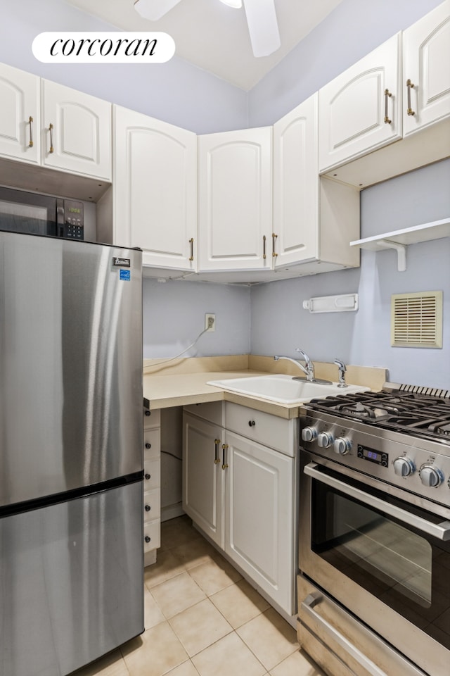 kitchen featuring stainless steel appliances, a sink, a ceiling fan, and white cabinets