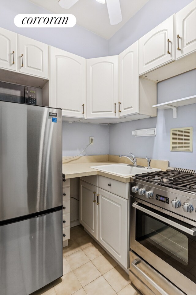 220 E 87th St Unit 5B, New York City, NY 10128 - kitchen featuring stainless steel appliances, light tile patterned flooring, white cabinets, and a ceiling fan