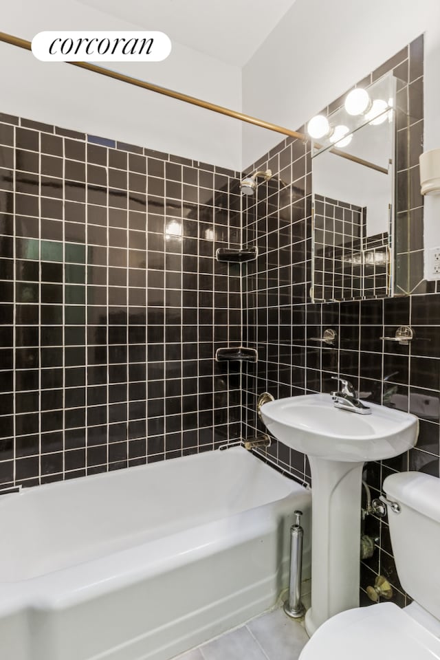 full bath featuring tile walls, toilet, bathtub / shower combination, and tile patterned flooring