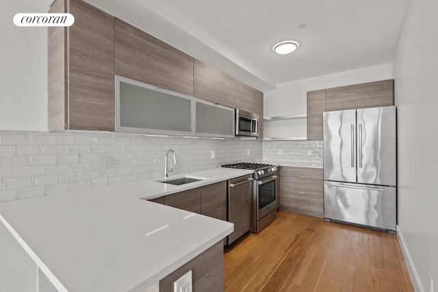 kitchen with a sink, appliances with stainless steel finishes, backsplash, open shelves, and modern cabinets