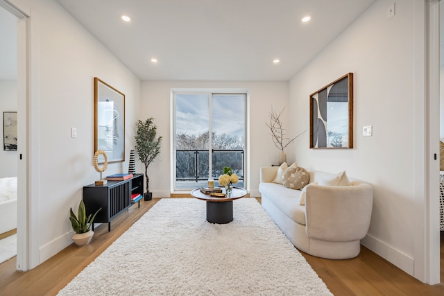 living room featuring baseboards, recessed lighting, and light wood-style floors