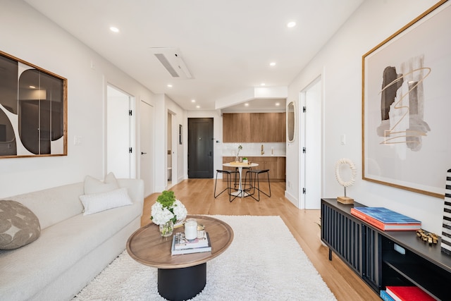 living room with light wood-style flooring and recessed lighting