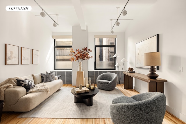 living room with track lighting, visible vents, a wealth of natural light, and wood finished floors