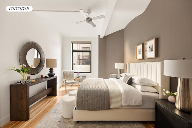 bedroom featuring lofted ceiling, visible vents, a ceiling fan, wood finished floors, and baseboards