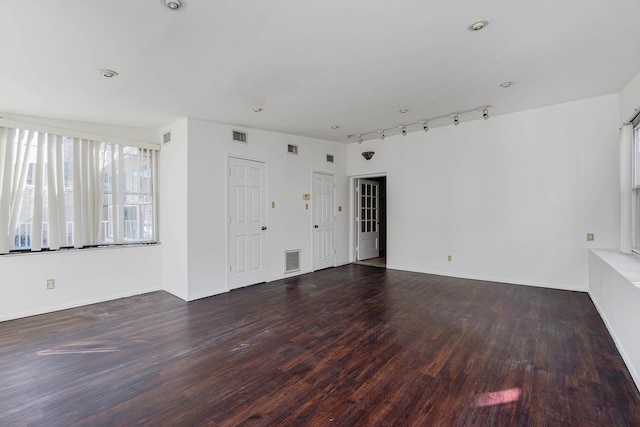 unfurnished living room with rail lighting, wood finished floors, and visible vents