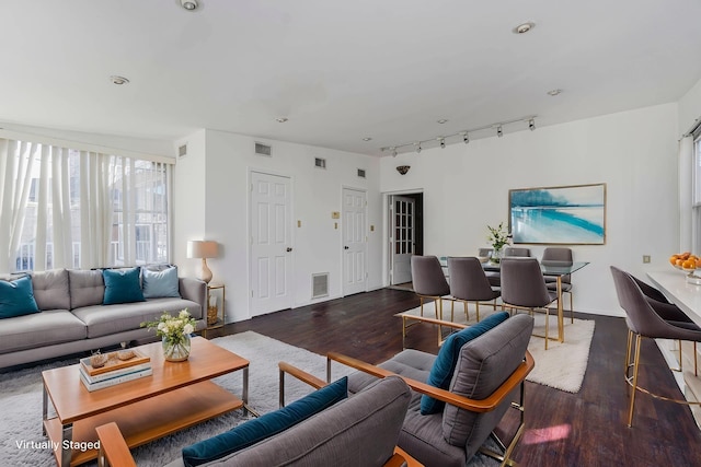 living area featuring visible vents, wood finished floors, and rail lighting