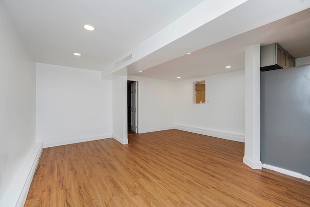 finished below grade area with recessed lighting, light wood-type flooring, baseboards, and visible vents