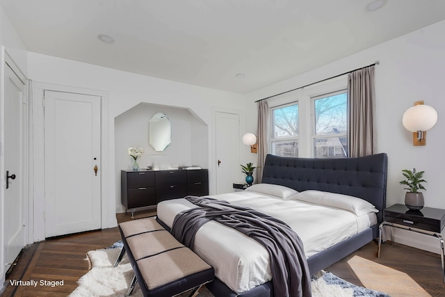 bonus room with arched walkways, radiator, baseboards, and wood finished floors