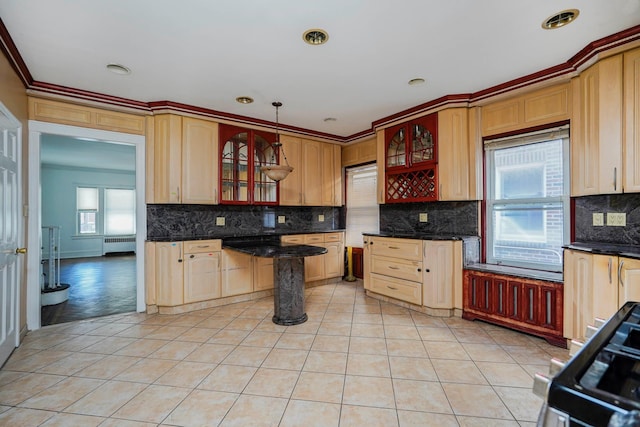 kitchen featuring radiator, light tile patterned floors, gas stove, glass insert cabinets, and tasteful backsplash