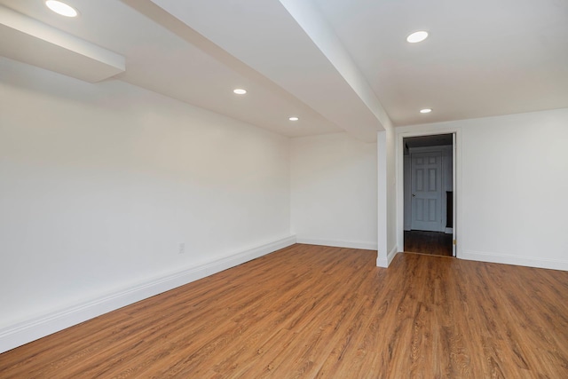 spare room with recessed lighting, baseboards, and wood finished floors