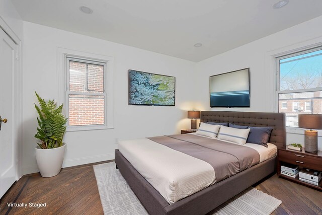 bedroom with wood finished floors and baseboards