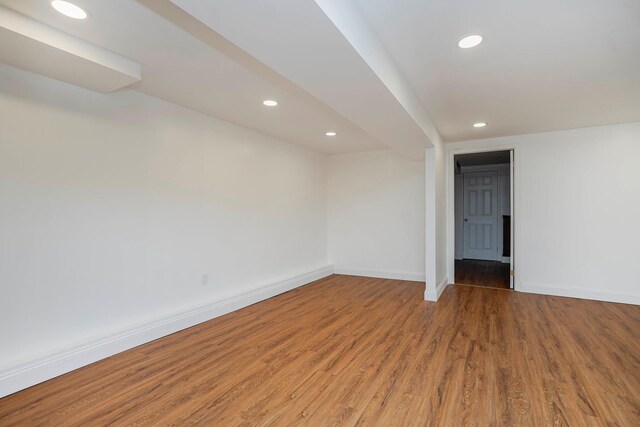 spare room featuring recessed lighting, wood finished floors, and baseboards