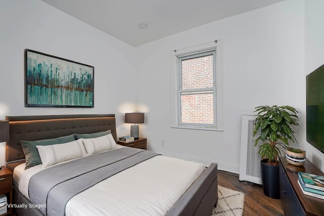 bedroom featuring baseboards and dark wood-style floors