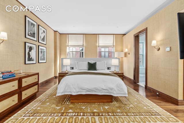 bedroom featuring baseboards, wallpapered walls, dark wood-style floors, and ensuite bath