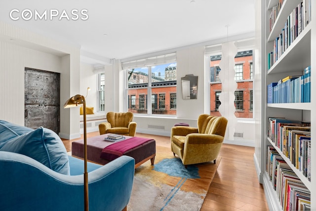 sitting room featuring wood finished floors, visible vents, and baseboards