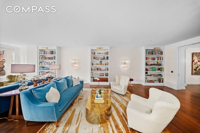 living room with baseboards, built in features, and wood finished floors