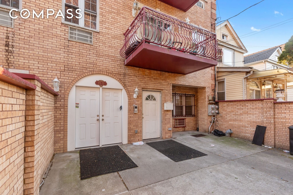 entrance to property featuring brick siding and a balcony