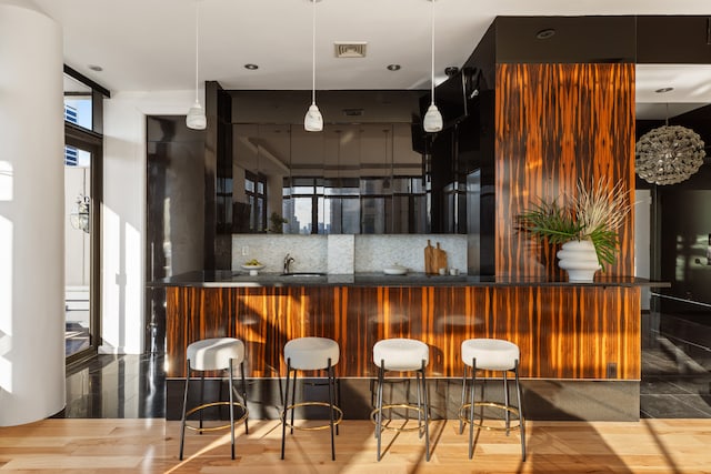 bar with bar area, floor to ceiling windows, visible vents, and decorative backsplash