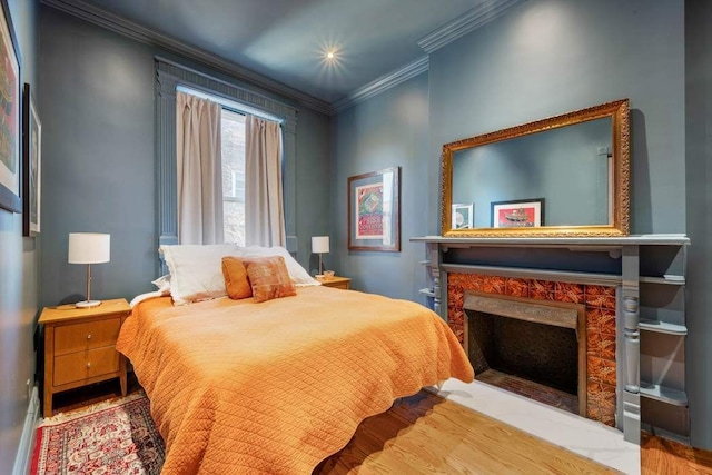 bedroom featuring ornamental molding and a premium fireplace