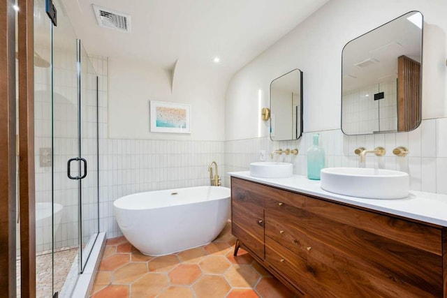 4 Agate Ct, New York City, NY 11213 - full bath with tile walls, double vanity, a freestanding tub, a stall shower, and tile patterned flooring