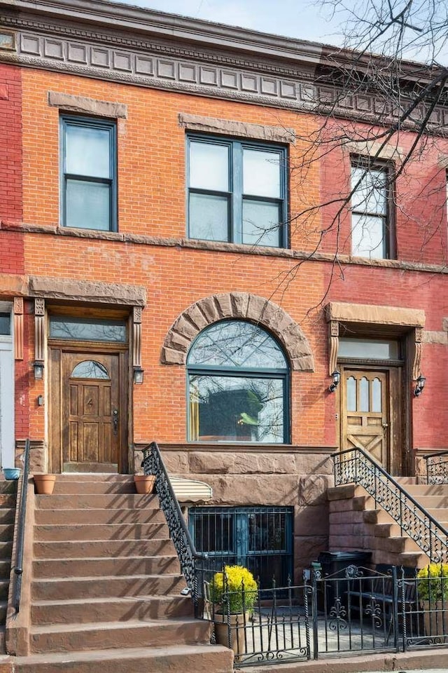 view of front of house with a fenced front yard and brick siding