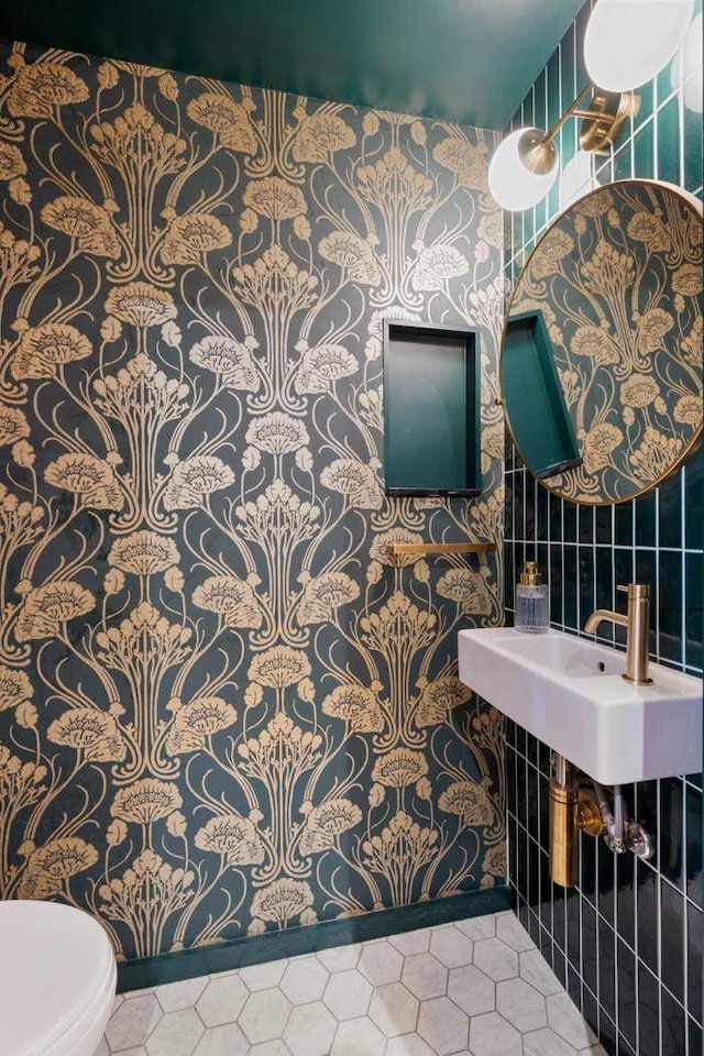 half bath featuring toilet, tile walls, and tile patterned floors