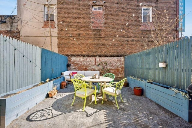 view of patio featuring outdoor dining space, a fenced backyard, and an outdoor living space