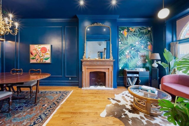 4 Agate Ct, New York City, NY 11213 - living room featuring wood finished floors, a decorative wall, crown molding, a large fireplace, and a chandelier