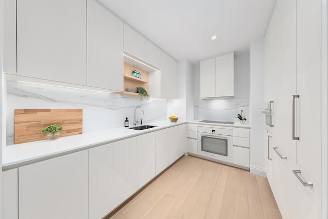 kitchen featuring modern cabinets, white cabinets, a sink, and white oven