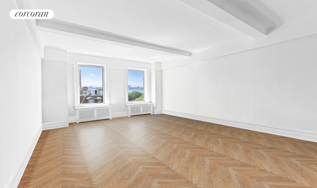 empty room featuring radiator heating unit, baseboards, beamed ceiling, and visible vents