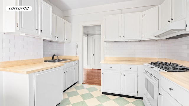 kitchen with white appliances, light floors, light countertops, under cabinet range hood, and a sink