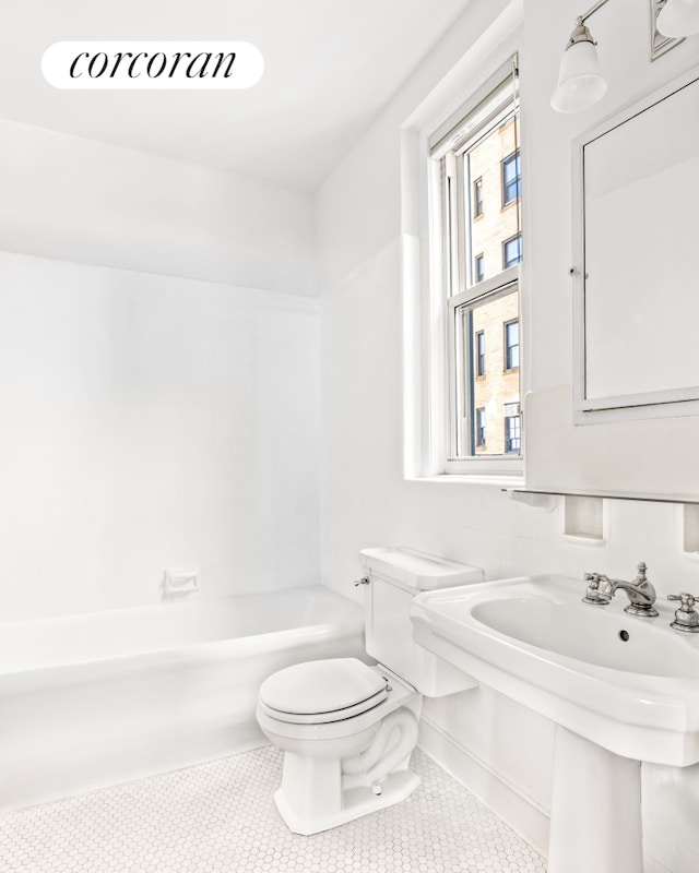 bathroom featuring toilet, tile patterned floors, and shower / bathing tub combination