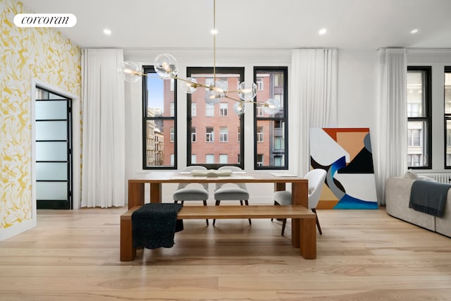 dining space featuring wood finished floors, wallpapered walls, a chandelier, baseboards, and visible vents
