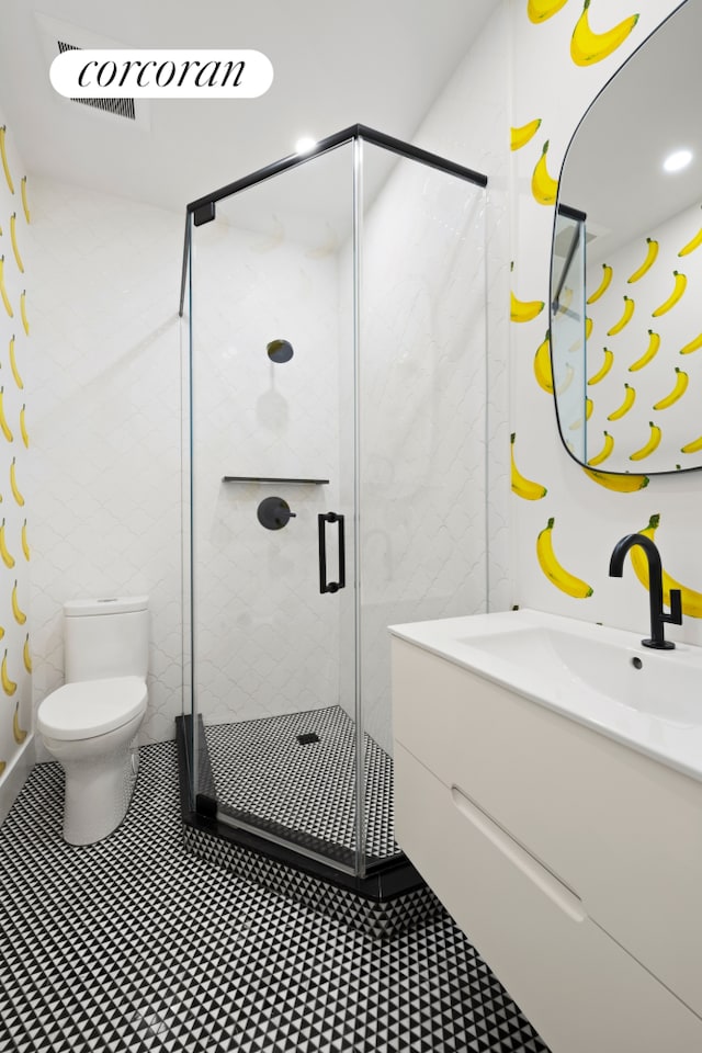 full bathroom with a shower stall, toilet, vanity, and tile walls