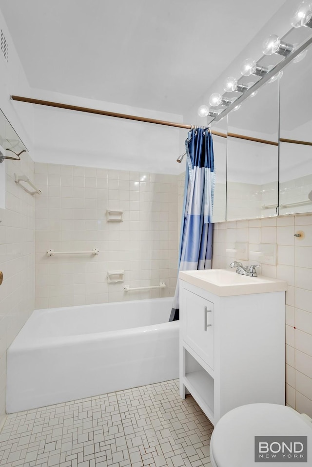 bathroom with tile patterned floors, vanity, tile walls, shower / bath combination with curtain, and toilet
