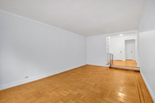 spare room with arched walkways, ornamental molding, and baseboards