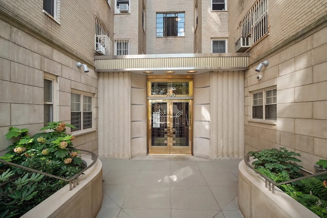 entrance to property featuring french doors and brick siding