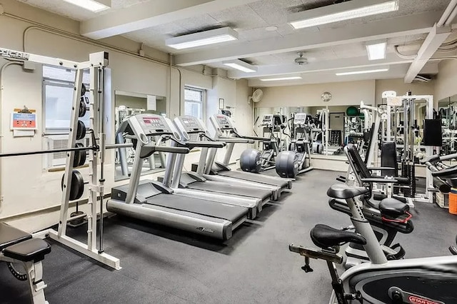 exercise room featuring beamed ceiling